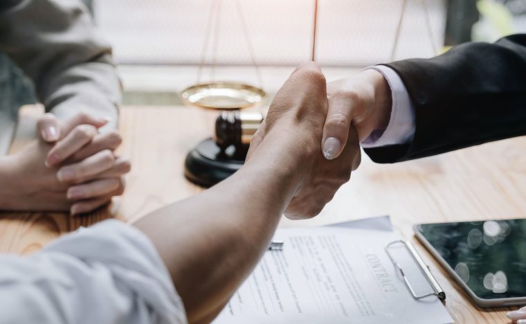 Close up of woman lawyer hand and man client shaking hand collaborate on working agreements with